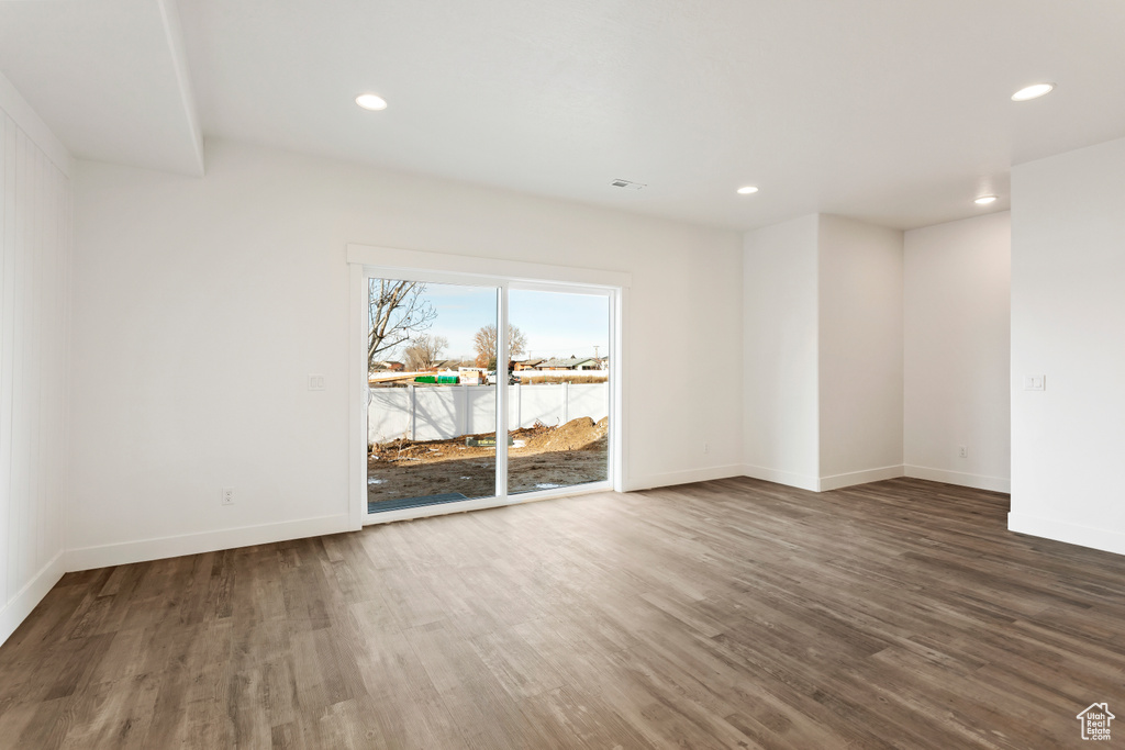 Empty room featuring wood finished floors, recessed lighting, and baseboards