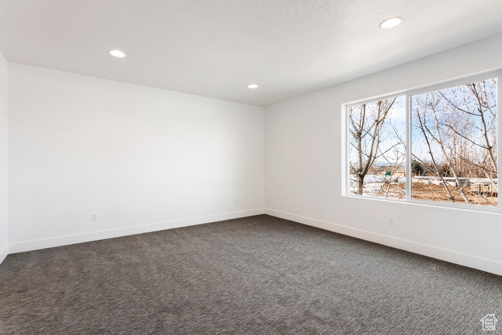 Unfurnished room featuring recessed lighting, dark carpet, and baseboards