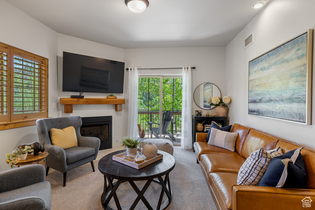 Carpeted living area featuring a fireplace