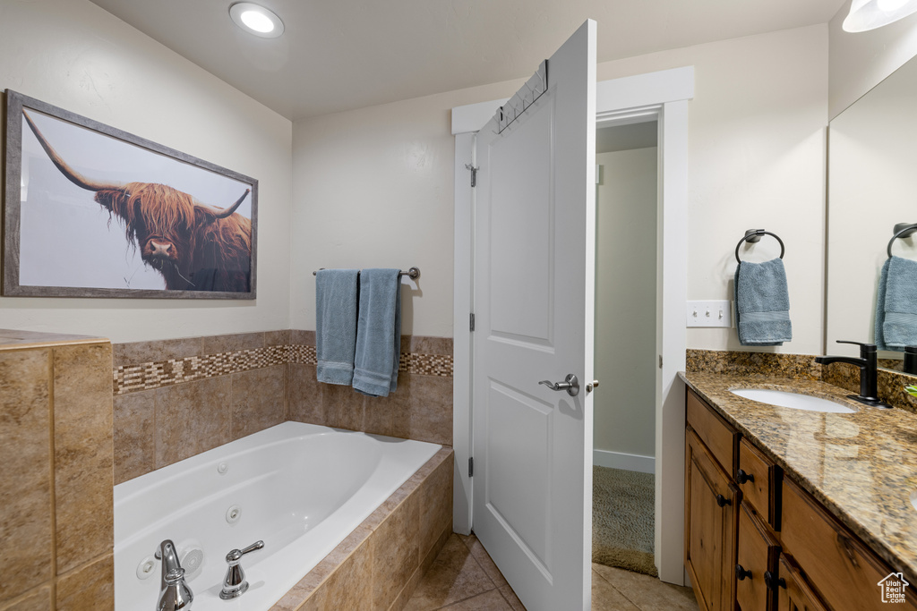 Bathroom featuring vanity, a jetted tub, tile patterned floors, and recessed lighting