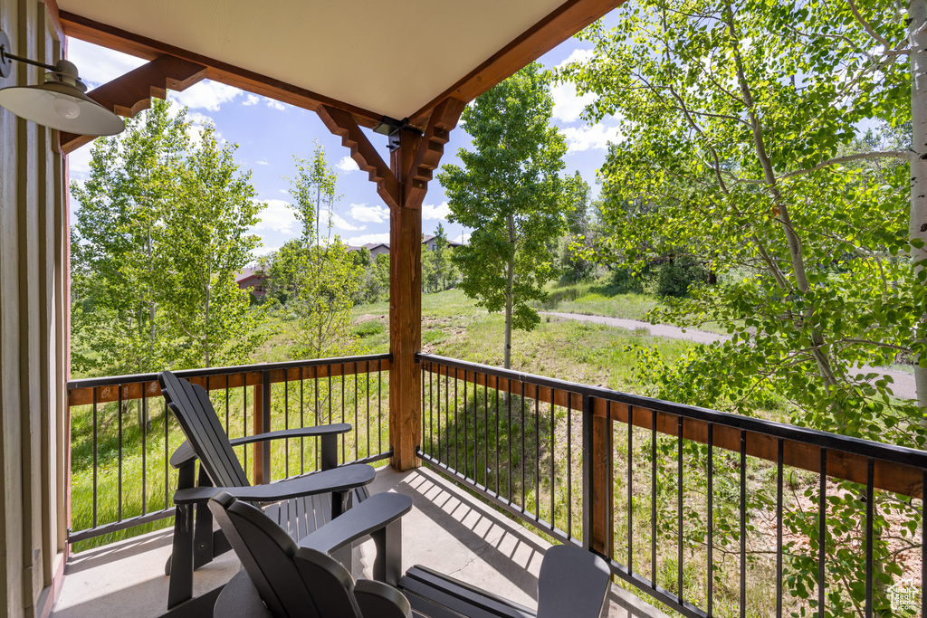 Balcony featuring view of wooded area