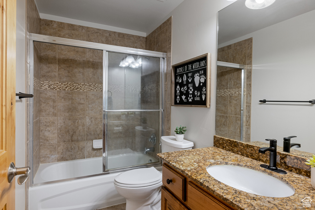 Full bathroom featuring vanity, toilet, and enclosed tub / shower combo