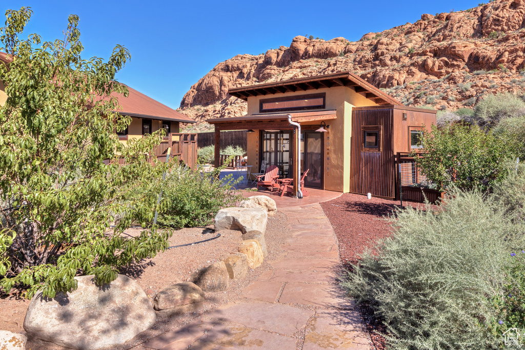 Pueblo revival-style home featuring a mountain view and a patio area