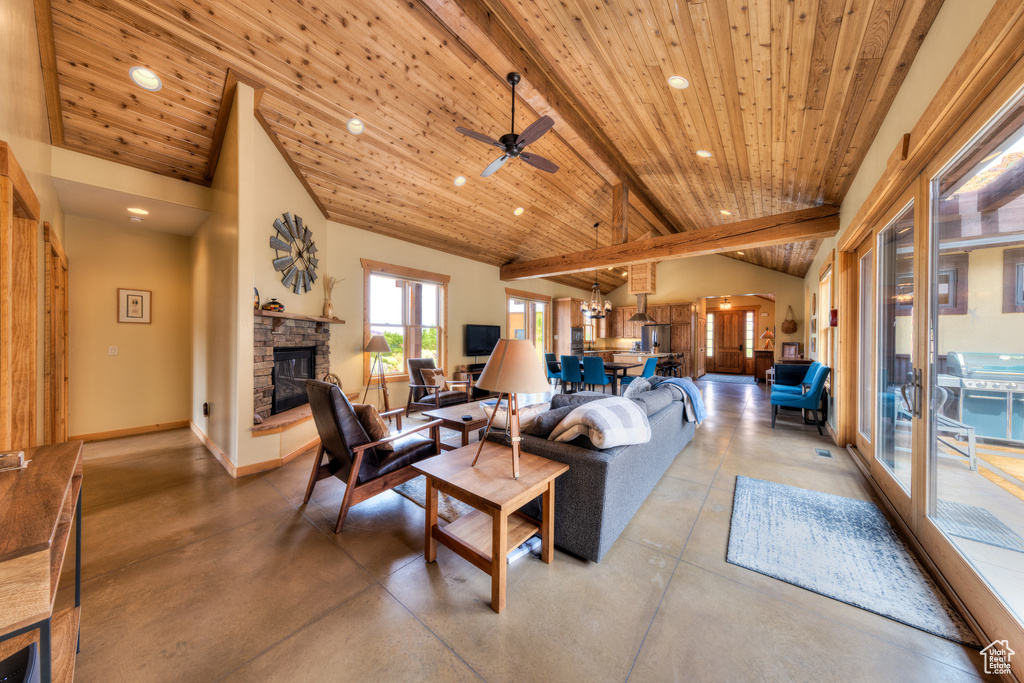 Living area featuring recessed lighting, finished concrete floors, a stone fireplace, wooden ceiling, and a ceiling fan