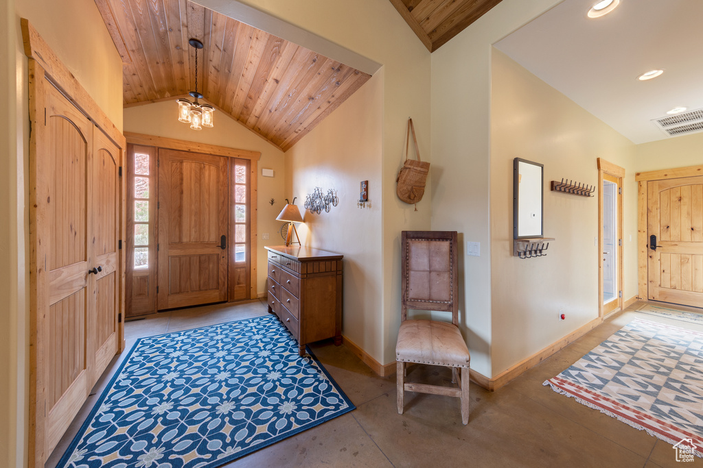 Foyer entrance with vaulted ceiling, baseboards, wood ceiling, recessed lighting, and concrete floors