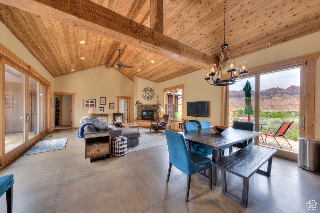Dining area with finished concrete flooring, wooden ceiling, a chandelier, a fireplace, and french doors