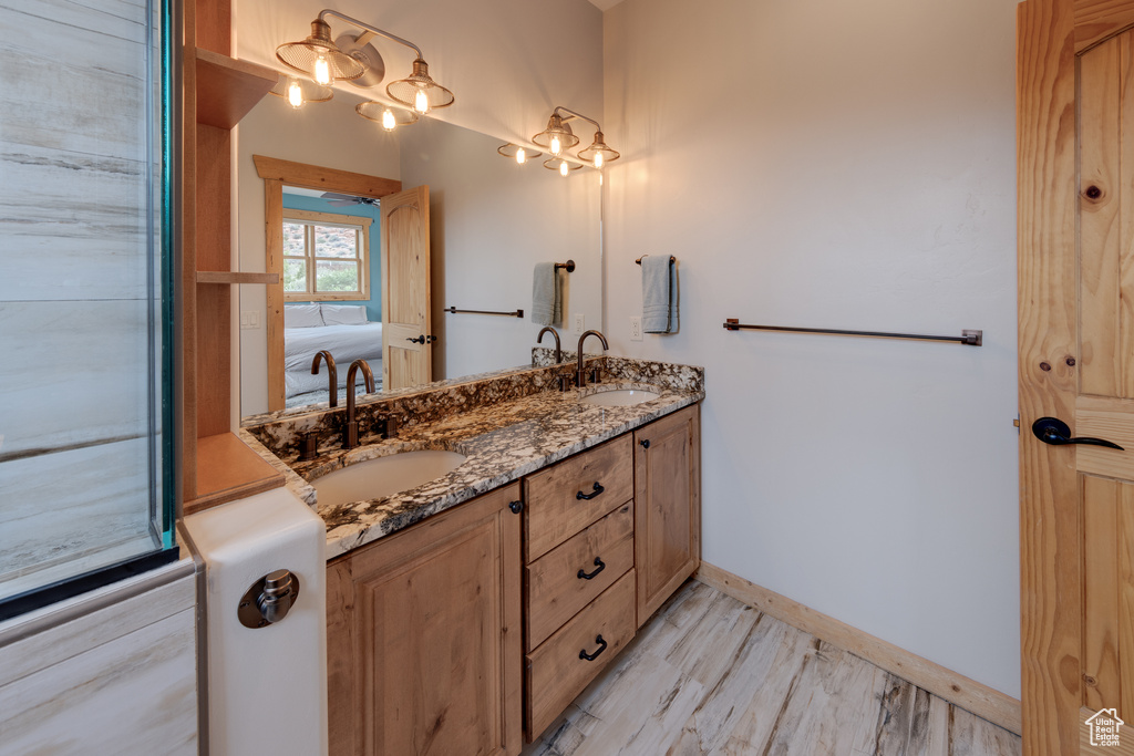 Full bathroom featuring double vanity and baseboards
