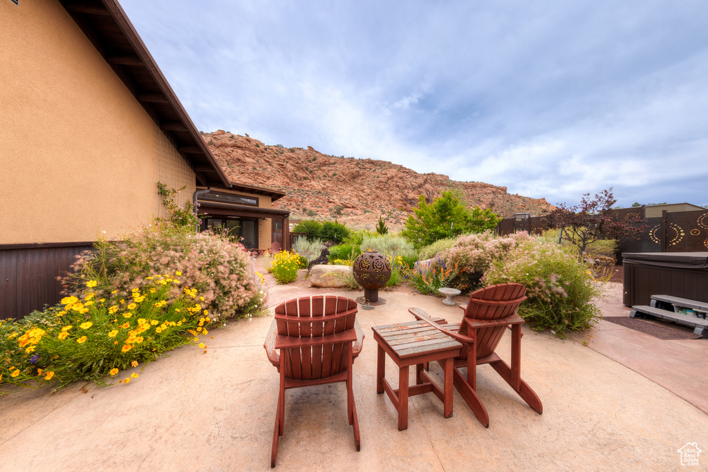 View of patio / terrace featuring a hot tub and a mountain view
