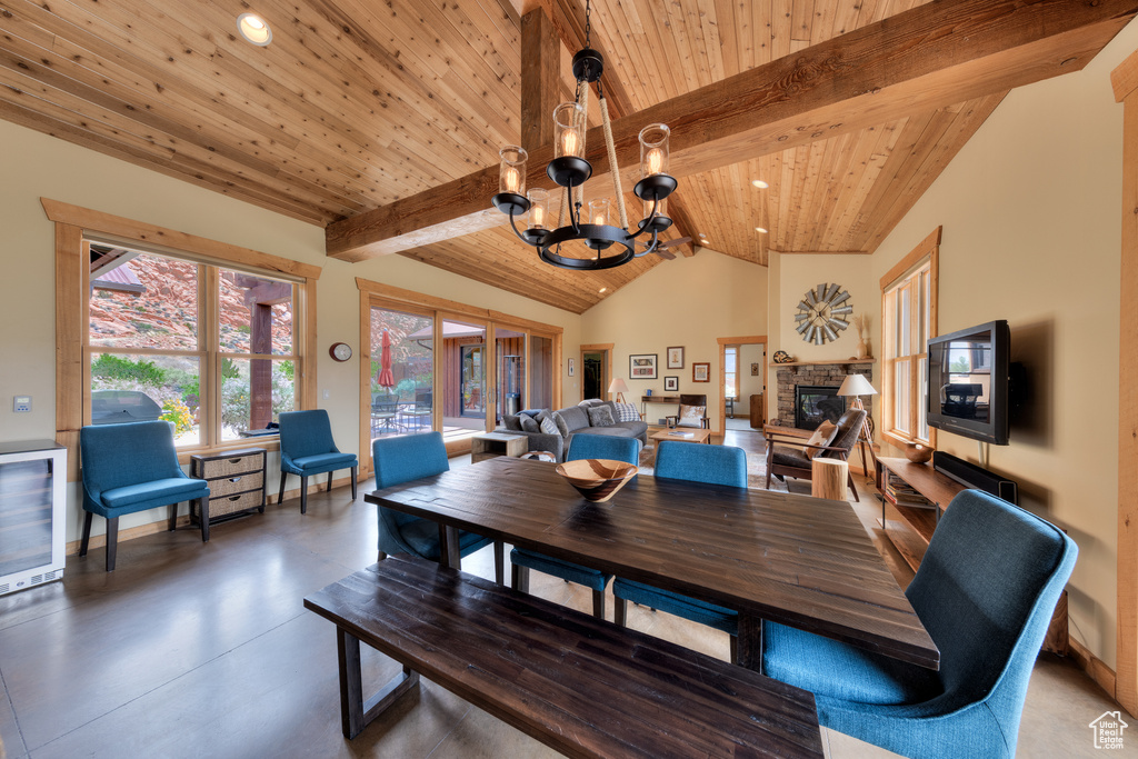Dining area with a chandelier, wooden ceiling, a fireplace, recessed lighting, and concrete floors