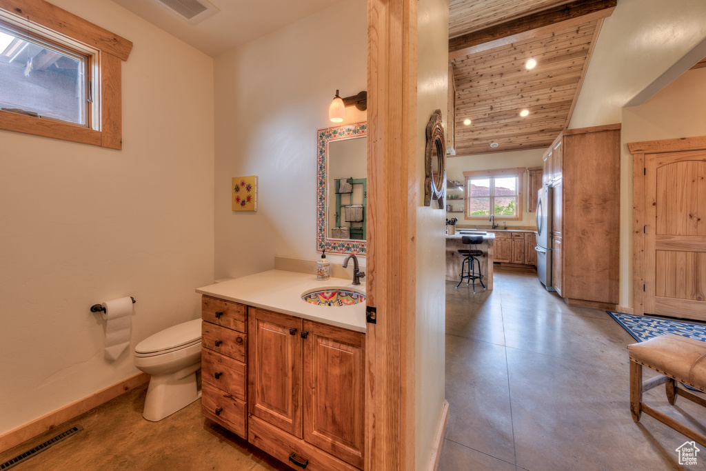 Bathroom featuring toilet, vanity, vaulted ceiling, baseboards, and wooden ceiling
