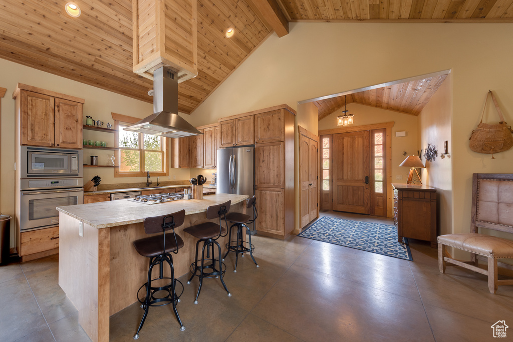 Kitchen with appliances with stainless steel finishes, island exhaust hood, wooden ceiling with exposed beams, open shelves, and a kitchen bar