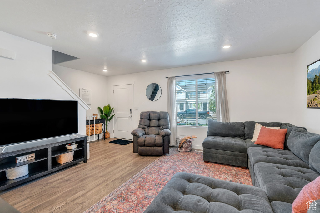 Living room featuring light wood-style floors, recessed lighting, and baseboards
