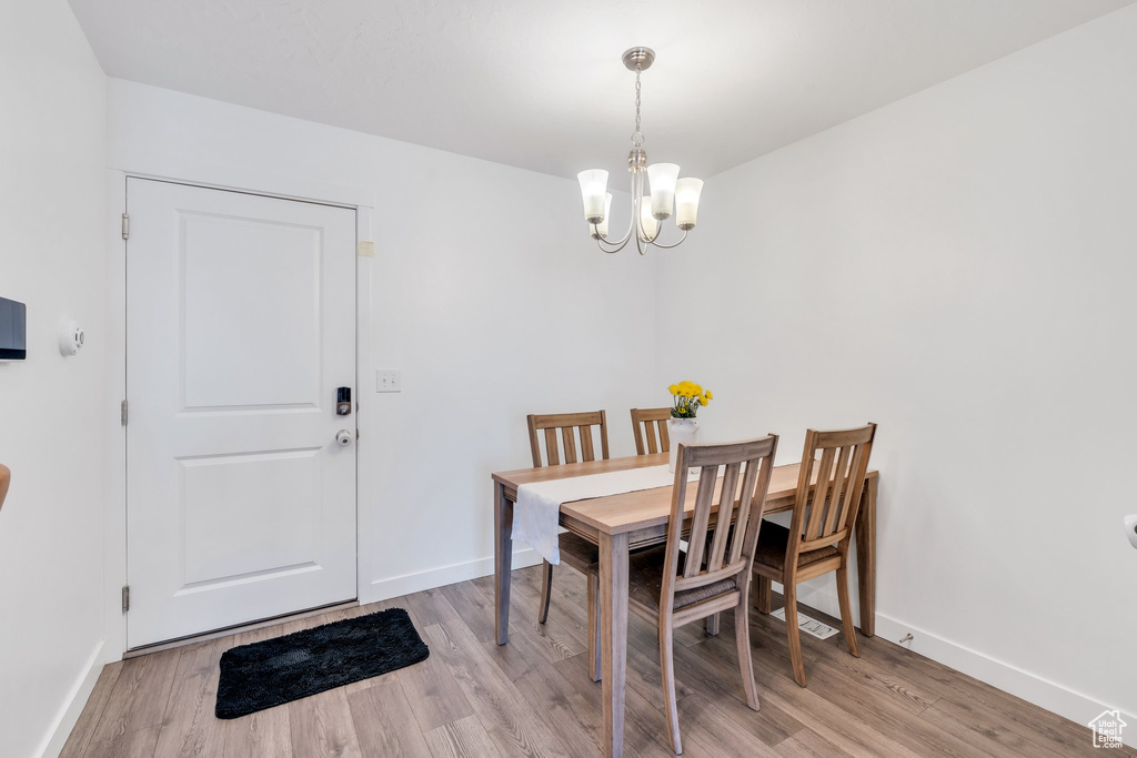 Dining area featuring a chandelier, light wood-type flooring, and baseboards