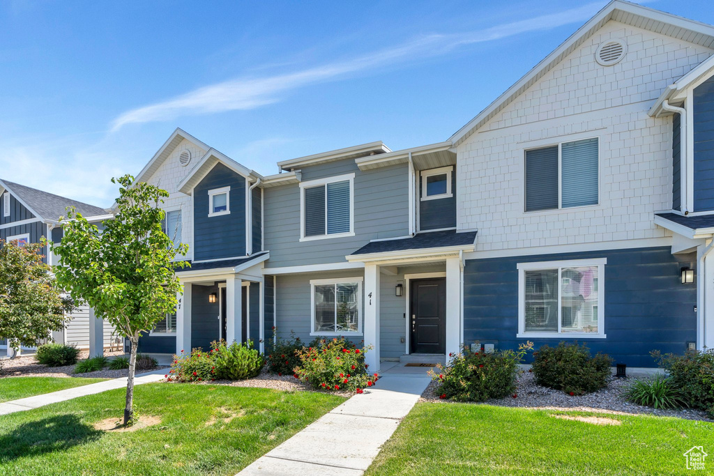 Townhome / multi-family property featuring a front lawn