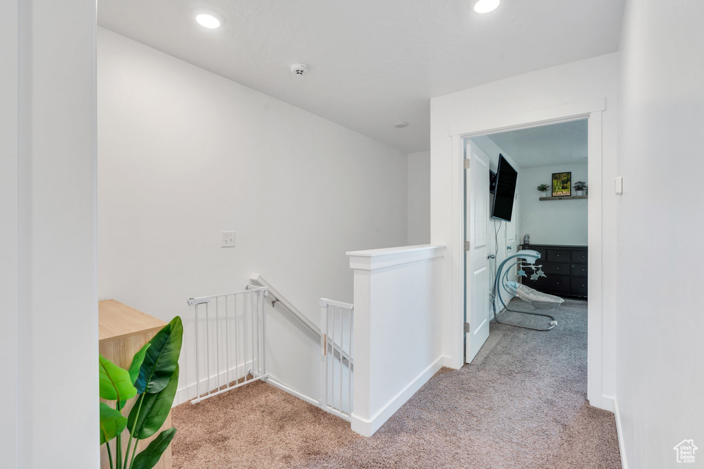 Hall with an upstairs landing, carpet flooring, recessed lighting, and baseboards
