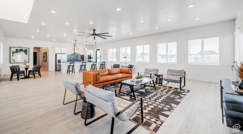 Living room featuring recessed lighting, light wood-style floors, and a ceiling fan