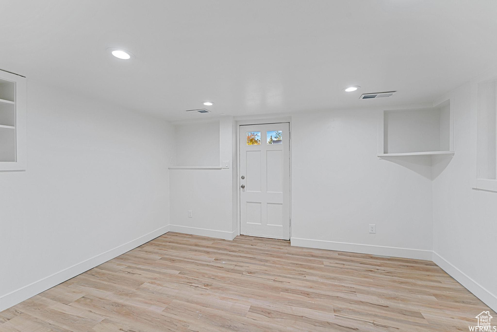 Basement with light wood finished floors, baseboards, and recessed lighting