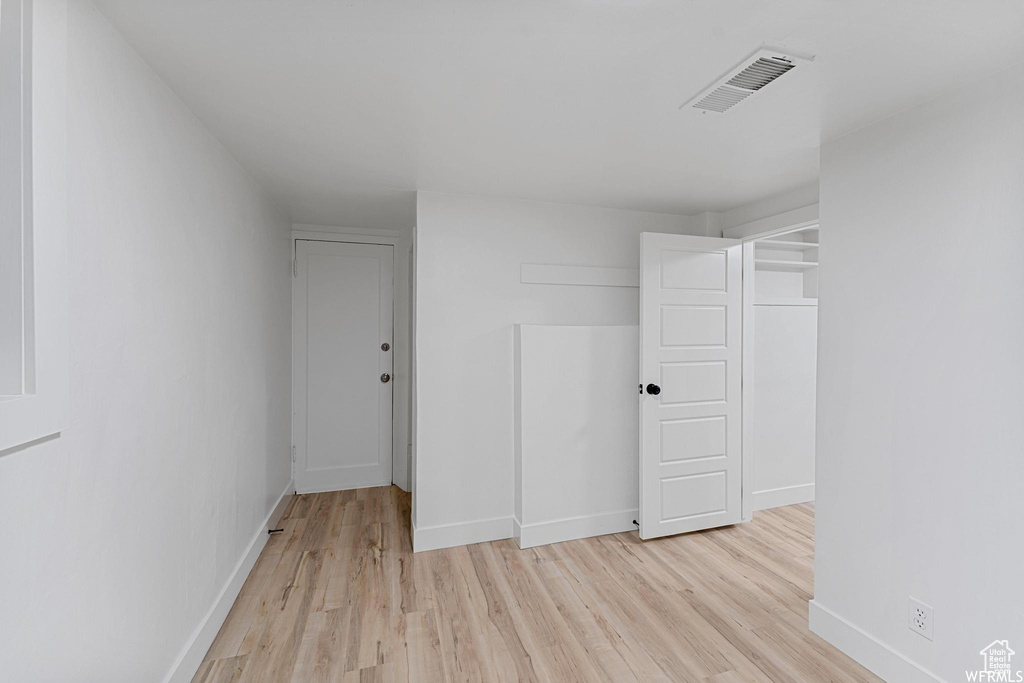 Spare room featuring light wood finished floors and baseboards