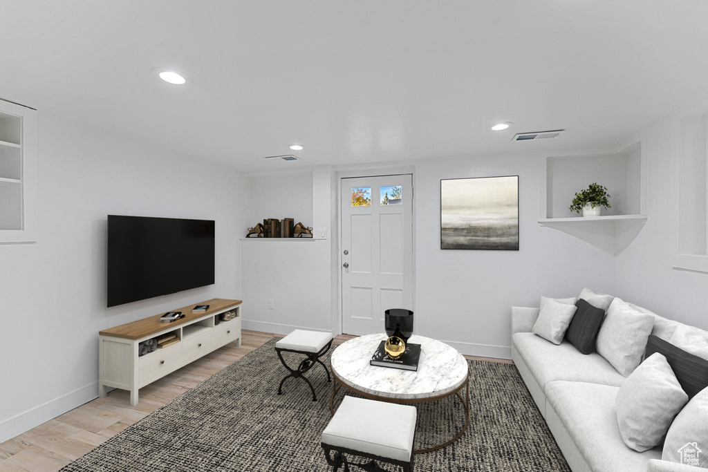 Living room featuring light wood-type flooring, baseboards, and recessed lighting