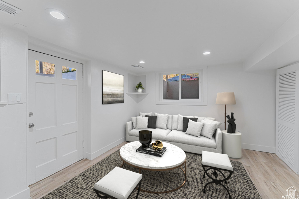 Living room with light wood-type flooring, baseboards, and recessed lighting