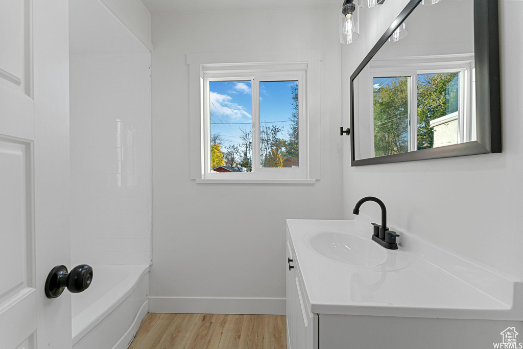 Bathroom with vanity, wood finished floors, and baseboards