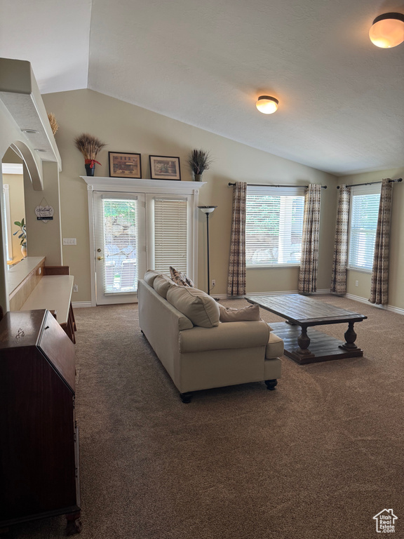 Living area featuring vaulted ceiling, carpet, and baseboards