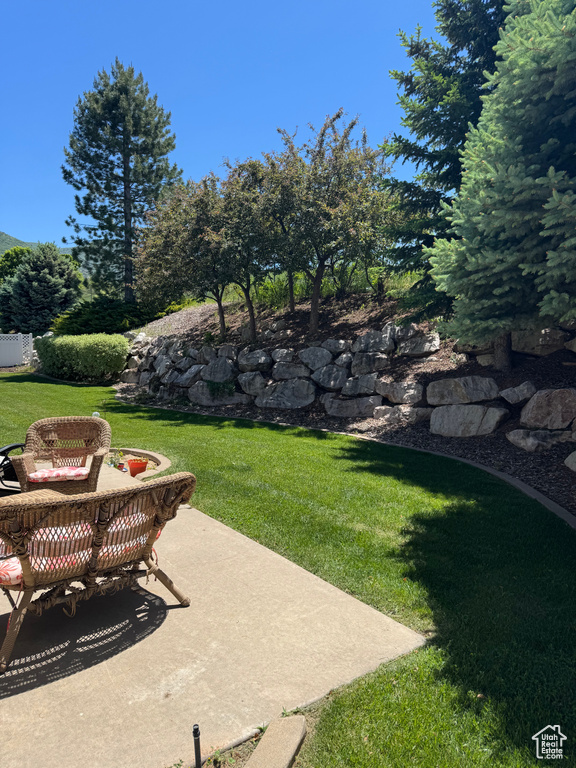 View of grassy yard featuring a patio area