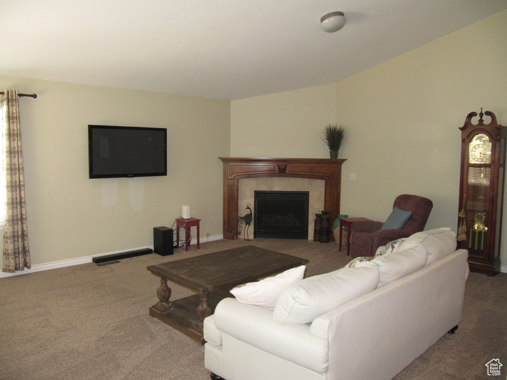 Living room with carpet flooring, a fireplace, and baseboards