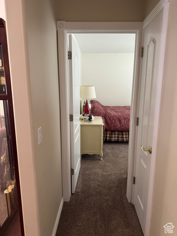 Hallway featuring dark carpet