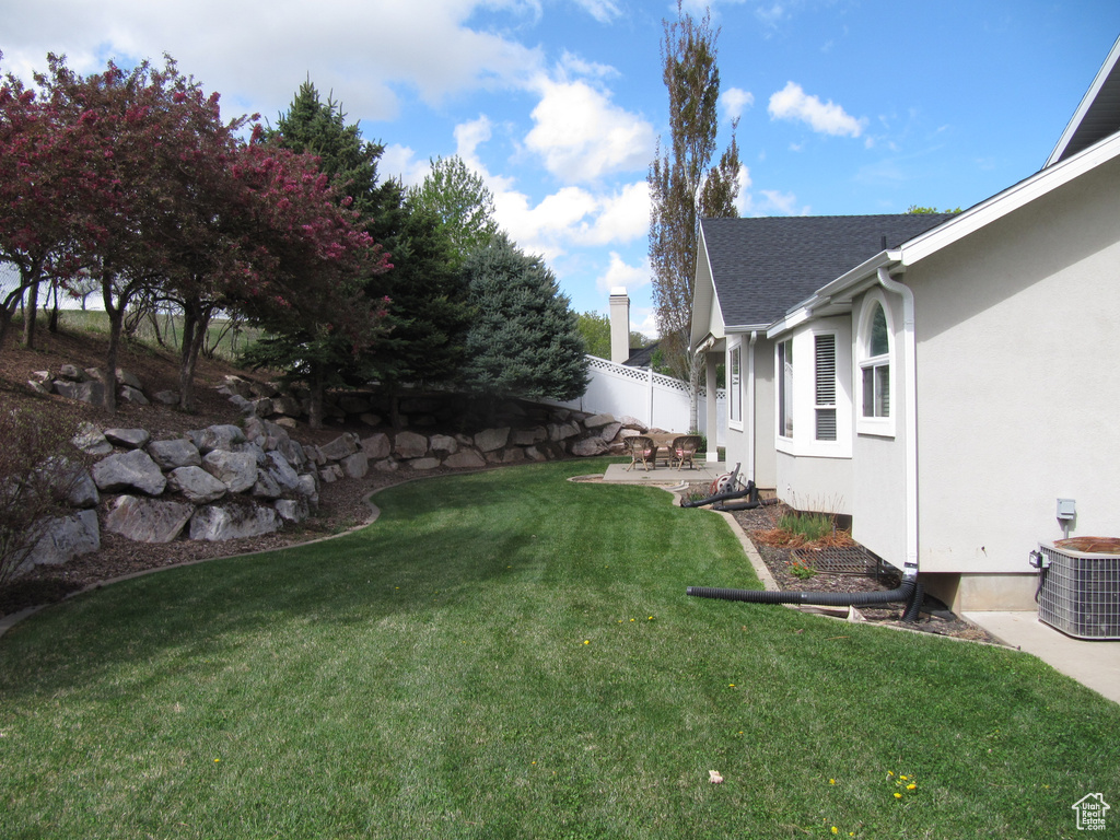 View of yard with central air condition unit and a patio