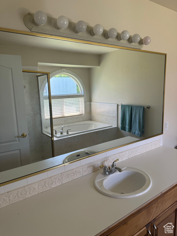 Full bath featuring a bath, vanity, and a shower stall