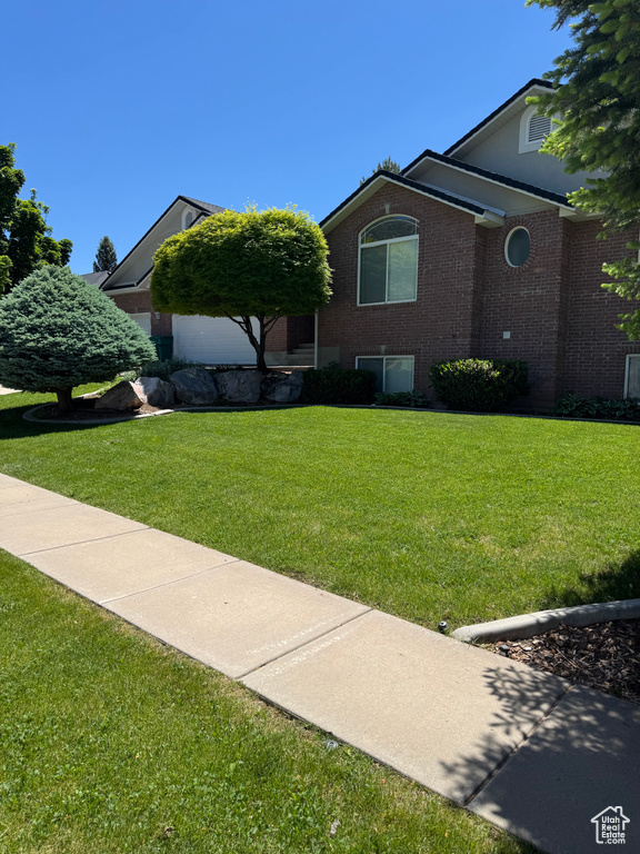 View of front facade featuring brick siding and a front lawn