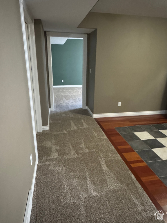 Hallway featuring carpet flooring and baseboards