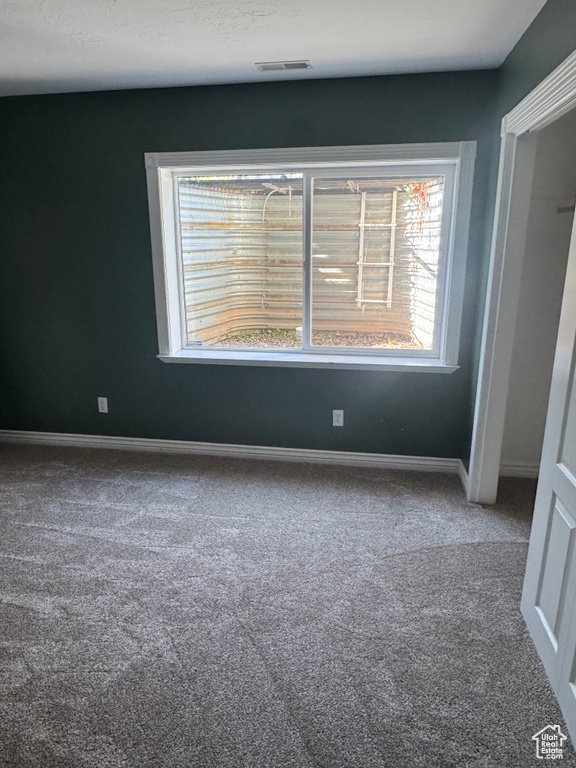 Unfurnished bedroom featuring carpet flooring, multiple windows, and baseboards