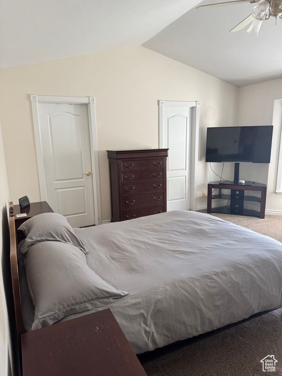 Carpeted bedroom featuring lofted ceiling and ceiling fan