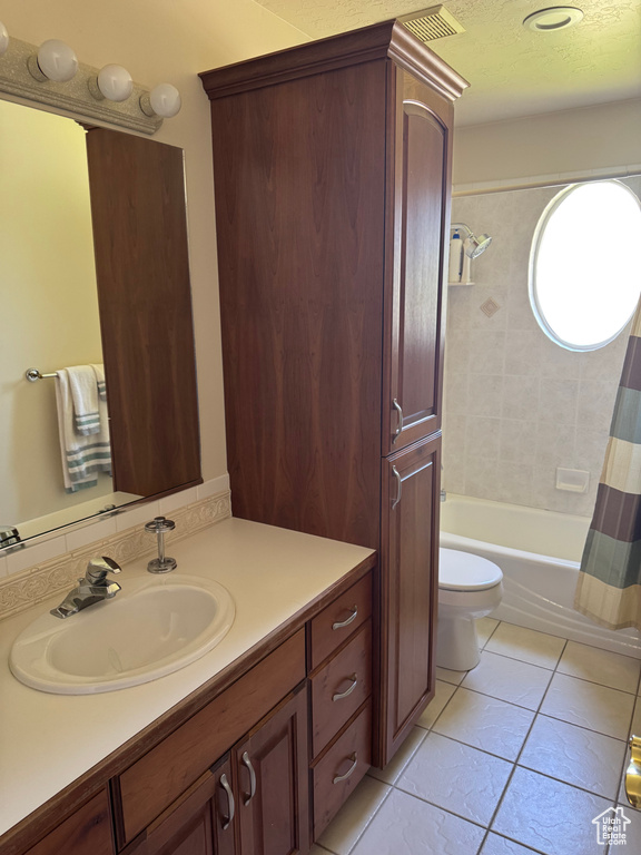 Bathroom with vanity, toilet, tile patterned floors, and shower / bath combo with shower curtain
