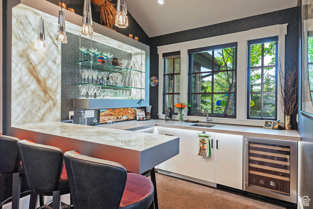 Community bar area featuring wine cooler, vaulted ceiling, recessed lighting, and carpet floors