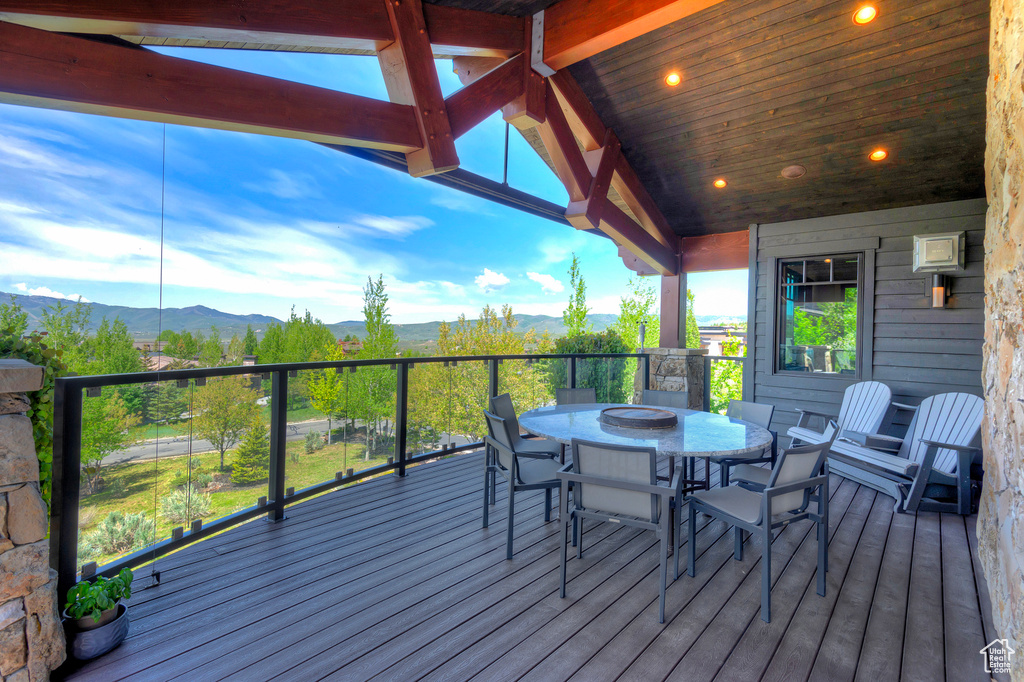 Deck with a mountain view and outdoor dining space