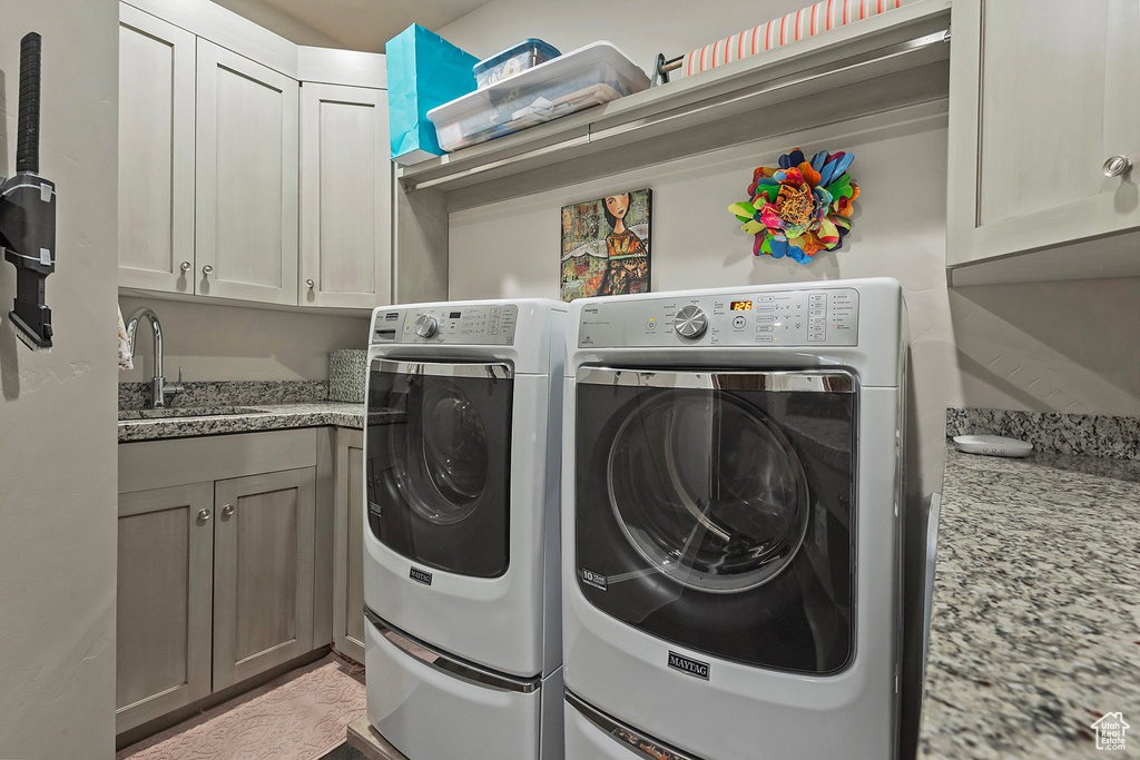 Laundry room with washer and clothes dryer and cabinet space