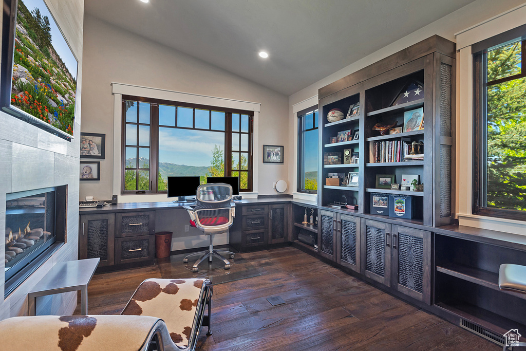 Office area with healthy amount of natural light, vaulted ceiling, dark wood-style flooring, recessed lighting, and built in desk