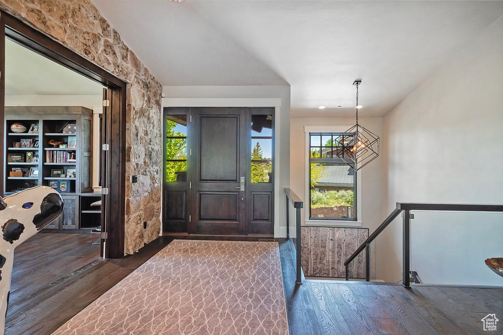 Entrance foyer featuring wood finished floors and a chandelier