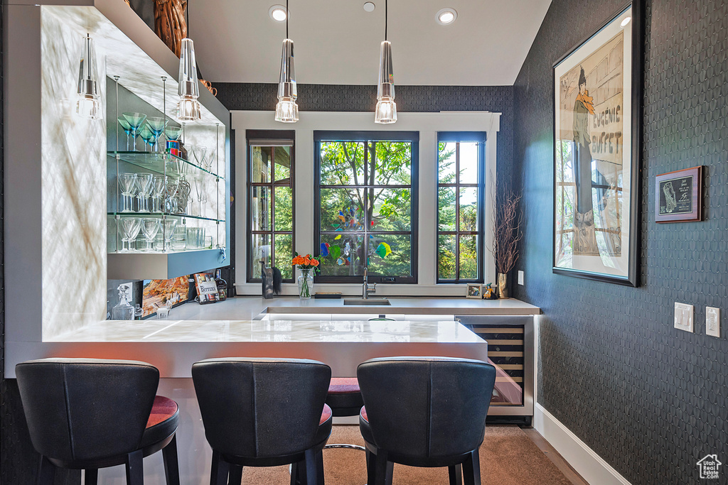 Bar with wine cooler, recessed lighting, pendant lighting, wallpapered walls, and baseboards