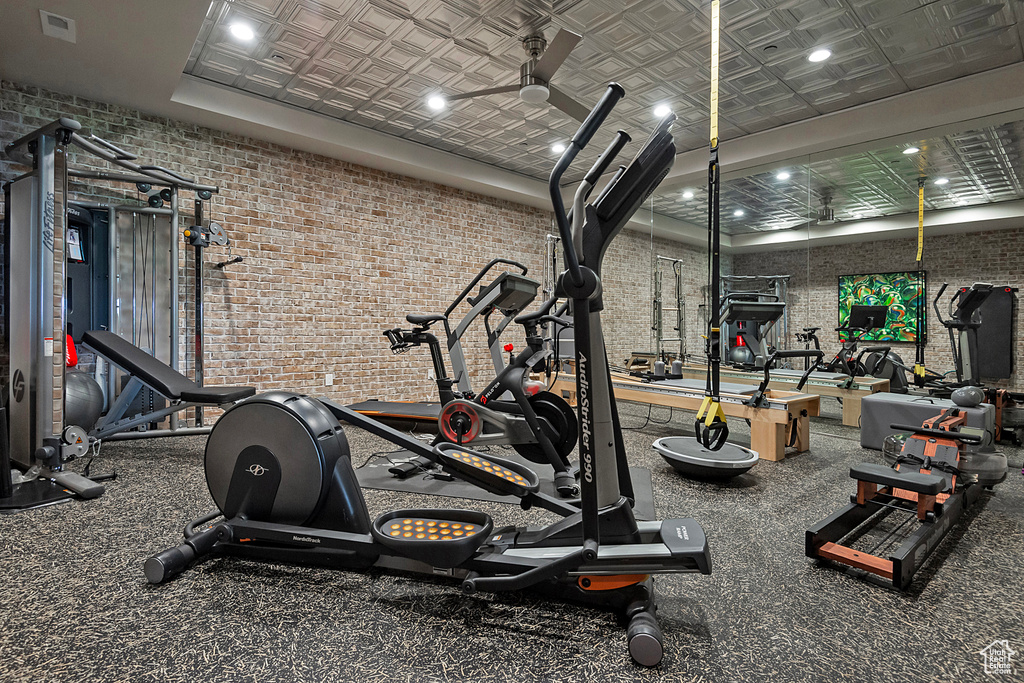 Workout area with brick wall and an ornate ceiling