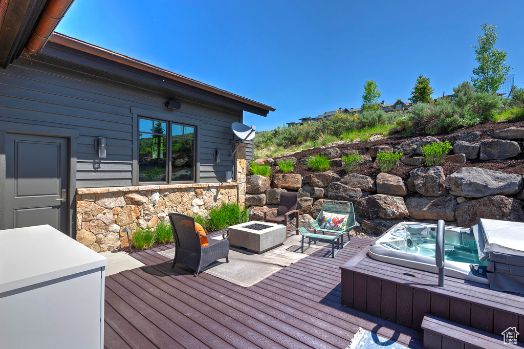 Wooden terrace featuring a fire pit