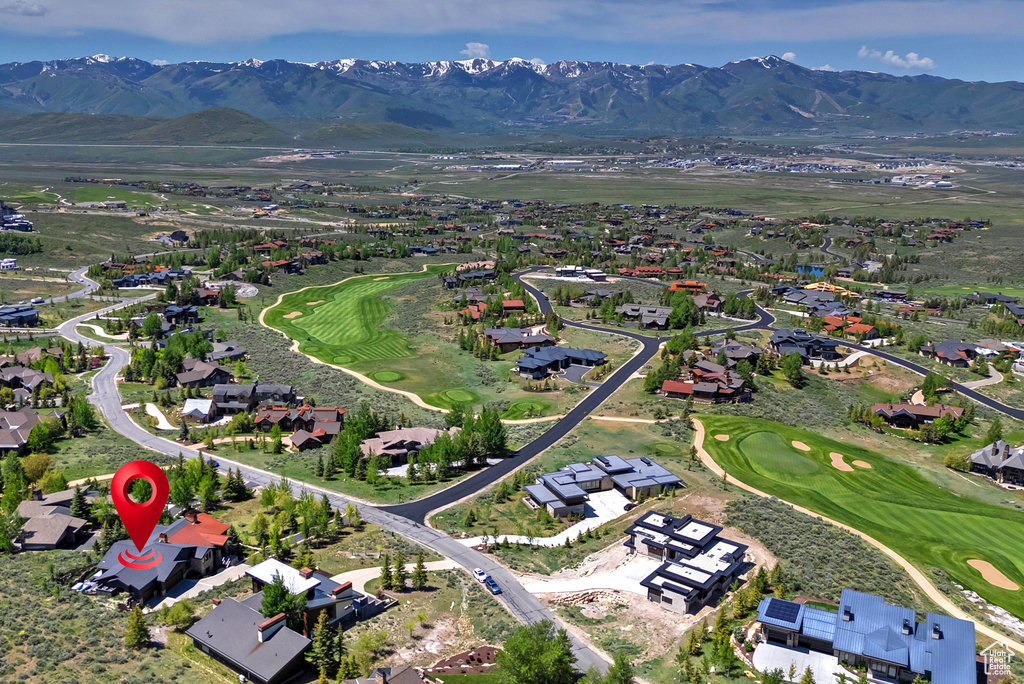 View of property location featuring mountains, a local golf course, and nearby suburban area