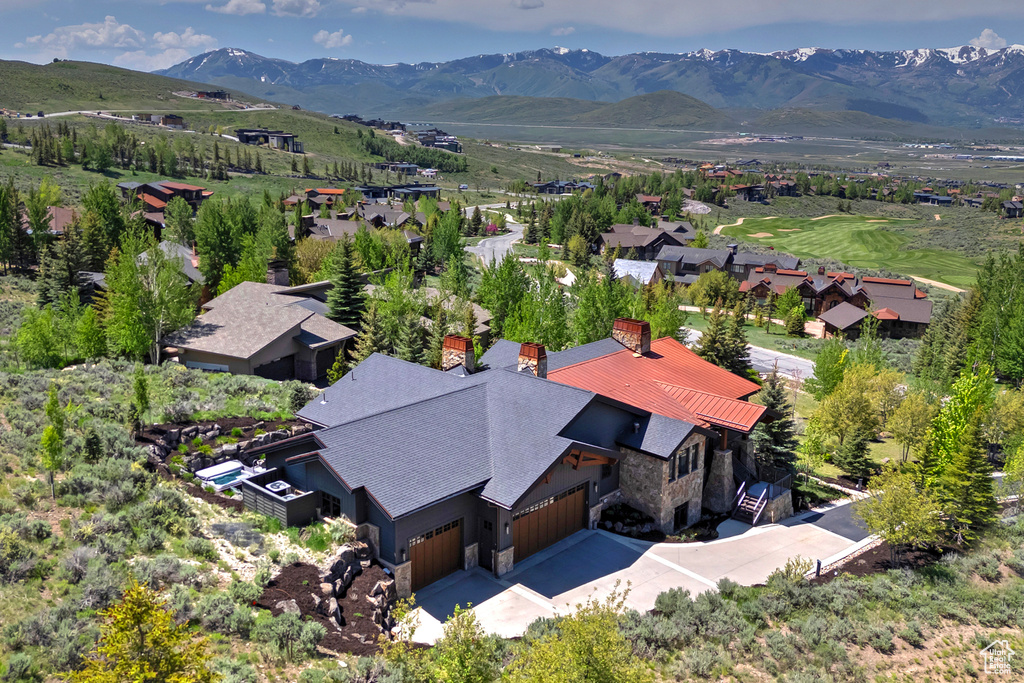 Aerial view of property and surrounding area featuring a mountain backdrop