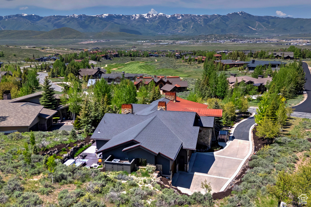 Aerial view of property and surrounding area with a mountain backdrop