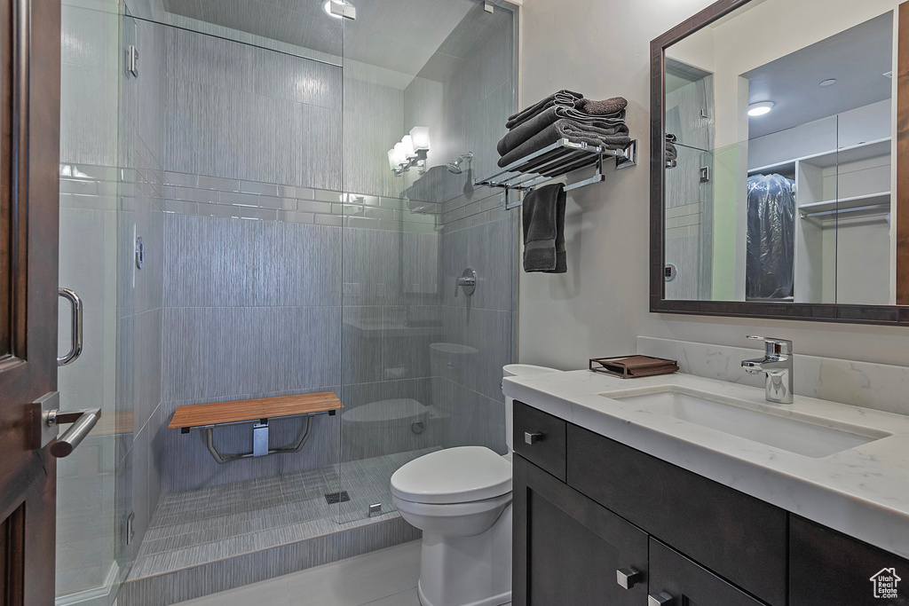 Bathroom featuring a shower stall, vanity, toilet, and tile patterned floors
