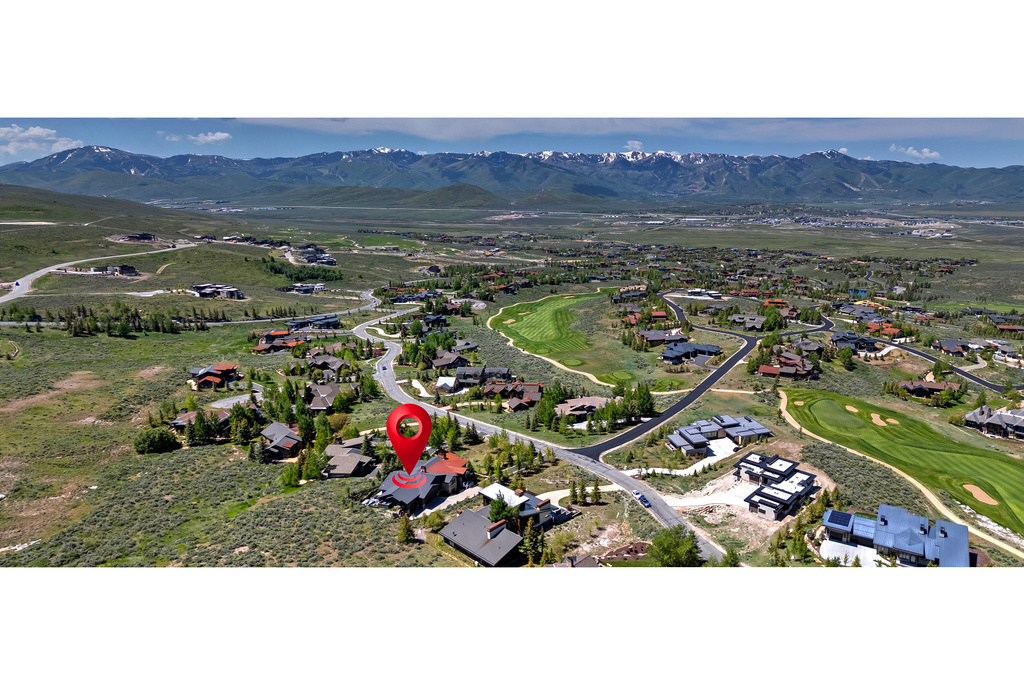 Aerial perspective of suburban area featuring mountains and a golf club