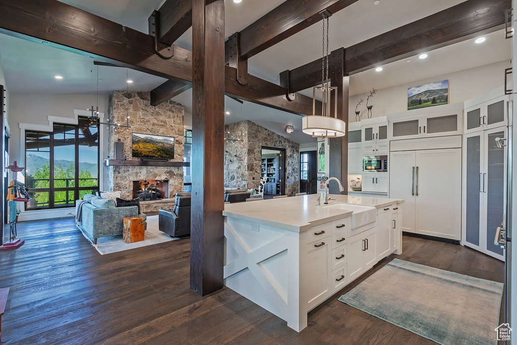 Kitchen with a sink, open floor plan, plenty of natural light, beamed ceiling, and high vaulted ceiling